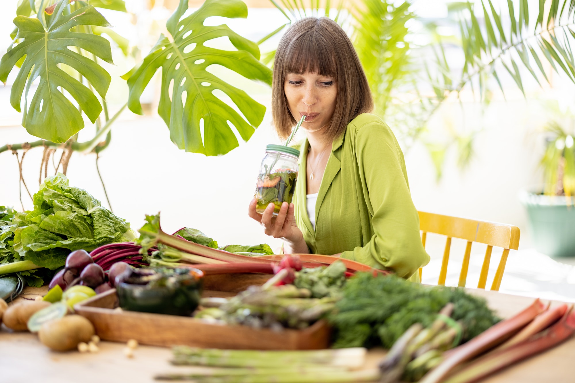 Woman with lots of fresh food ingredients indoors